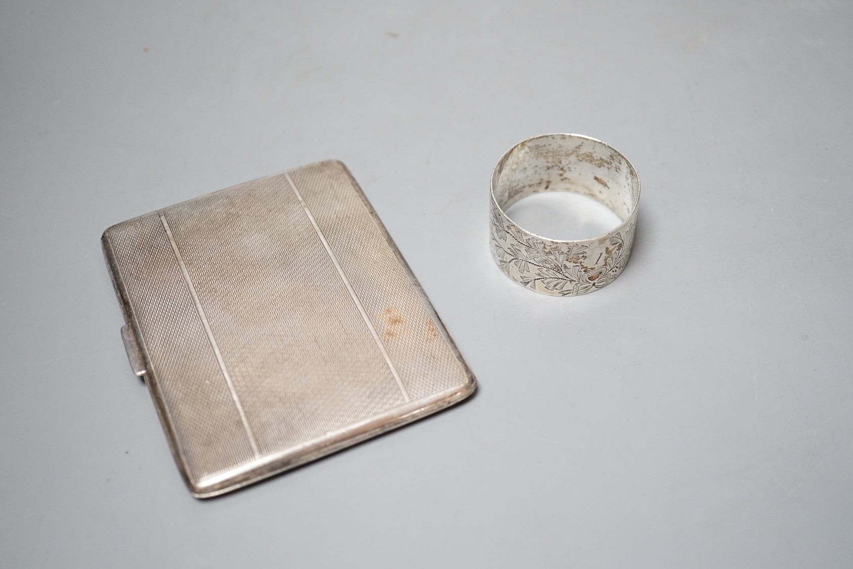 A silver cigarette case and a silver napkin ring.